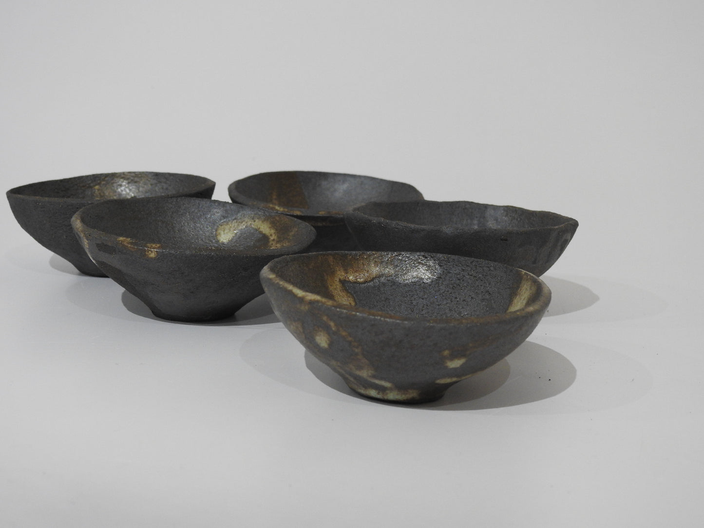 The SOIL SMALL DIP BOWL showcases authentic Greek craftsmanship with an earthy, textured finish and natural color variations—each handmade stoneware bowl is unique.