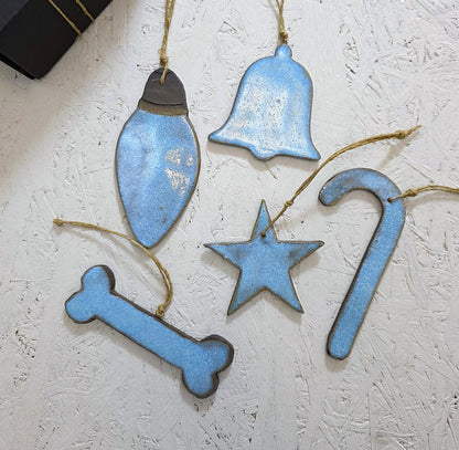 Box 2 features five handcrafted ceramic ornaments—a light bulb, bell, star, candy cane, and bone—hung on twine and displayed on a textured white surface, making them perfect for Christmas gifting.