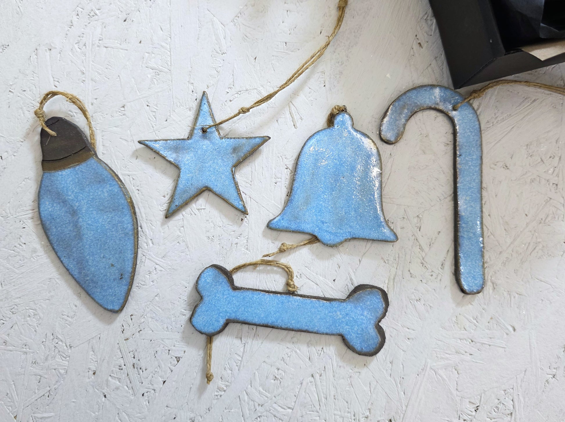 Box 2 features five handcrafted ceramic ornaments—holiday bulb, star, bell, candy cane, and bone—beautifully arranged on a white textured surface, making them an ideal Christmas gift.