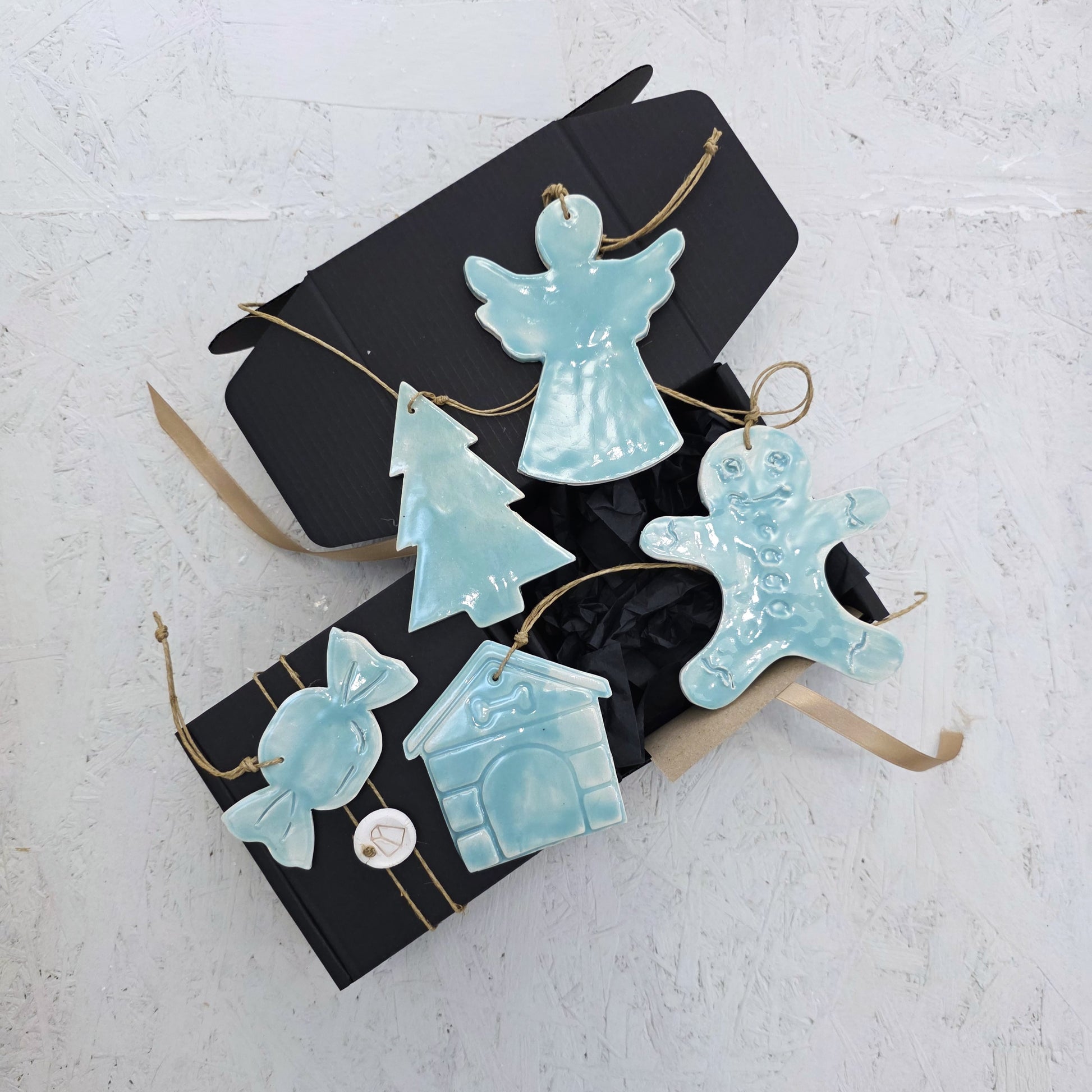 Box 4: A luxury gift box featuring handcrafted ceramic ornaments—angel, Christmas tree, gingerbread person, candy, and doghouse—each tied with twine and beautifully arranged. An elegant Christmas gift idea.