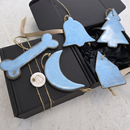 Box 5 features five handcrafted light blue ceramic ornaments—a bone, bell, tree, moon, and house—displayed with two black luxury gift boxes tied with string, making it perfect for thoughtful Christmas gifting.