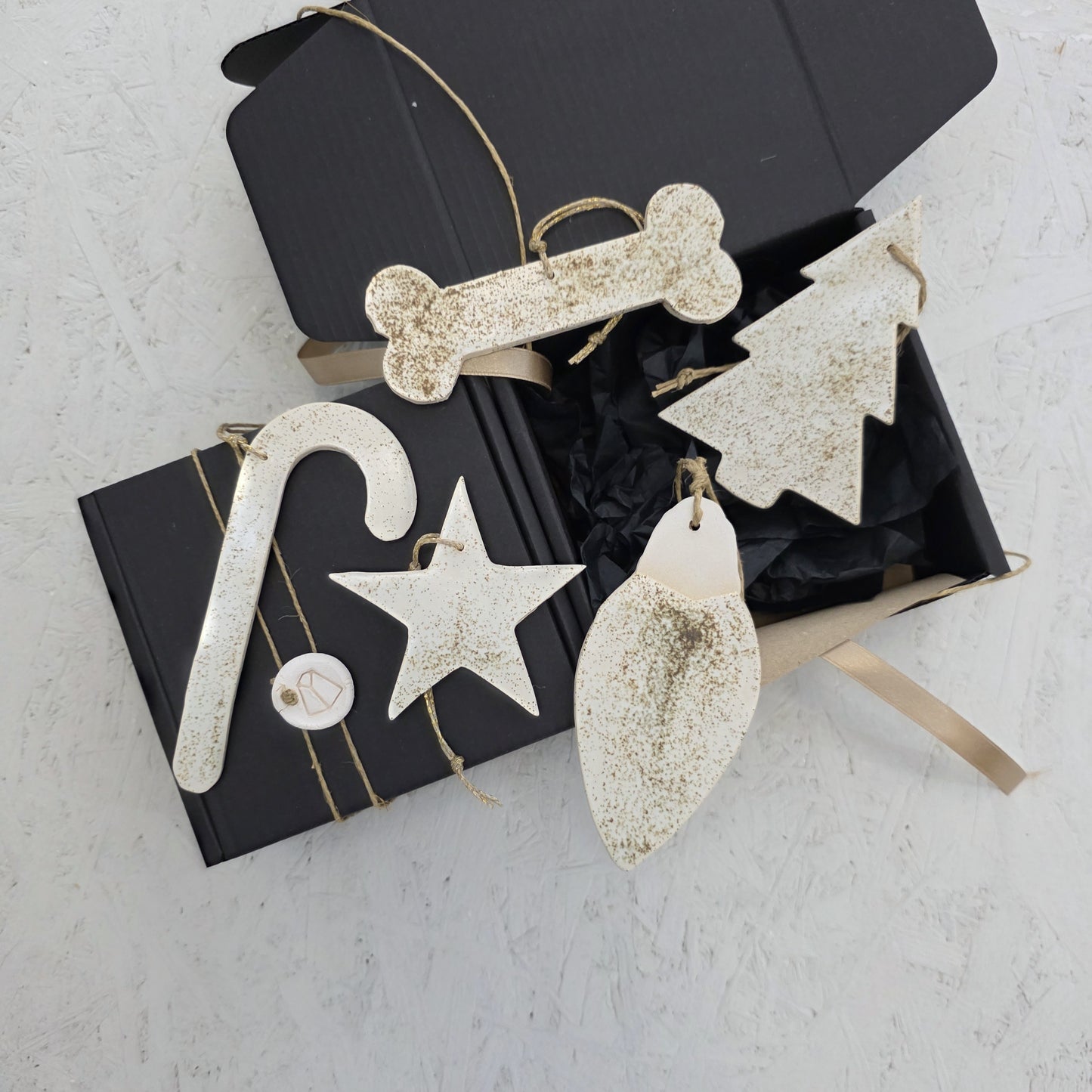 Box 7 features cream-colored, textured ceramic ornaments in festive shapes, presented in a handcrafted gift box with tan ribbon. Perfect for Christmas gifting, these elegant accents enhance any holiday décor.