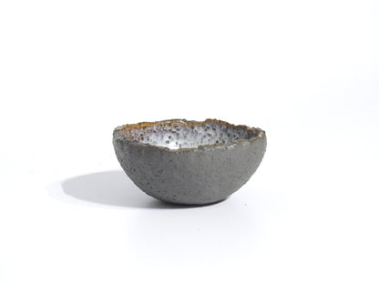 The STONE DIP BOWL, a small handmade piece inspired by Greek pottery with a textured gray exterior and glazed white-speckled interior, is displayed on a plain white background.