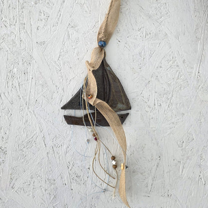 Decorative wall hanging with fabric and beads on a textured white background