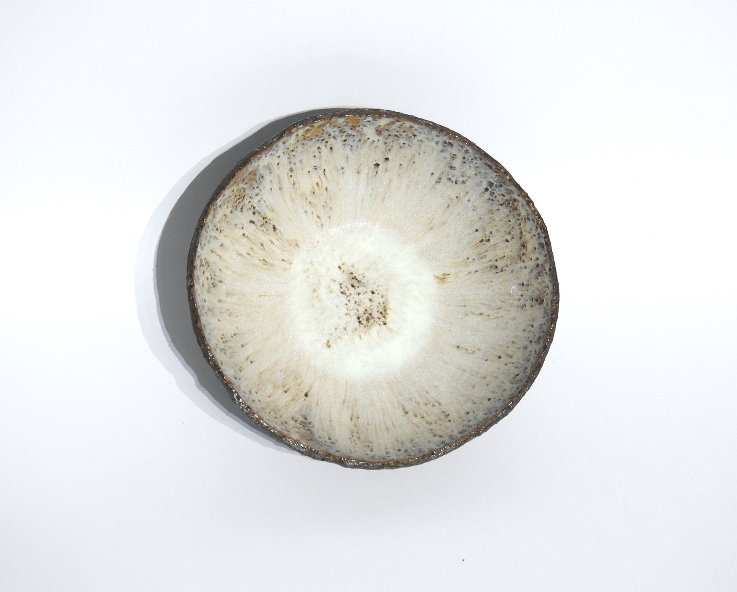 The STONE SOUP BOWL is a round, 18 cm ceramic bowl with a textured off-white interior and speckled gray-brown edges, shown from above on a plain white background.