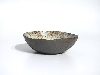 The STONE SOUP BOWL is a handmade 18 cm ceramic piece with a rough, textured gray exterior and a speckled, glossy white interior, shown against a plain white background.
