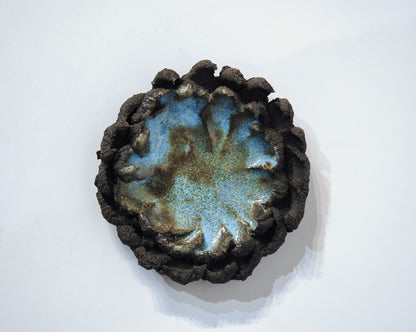Ceramic ashtray with blue glaze and textured brown rim 