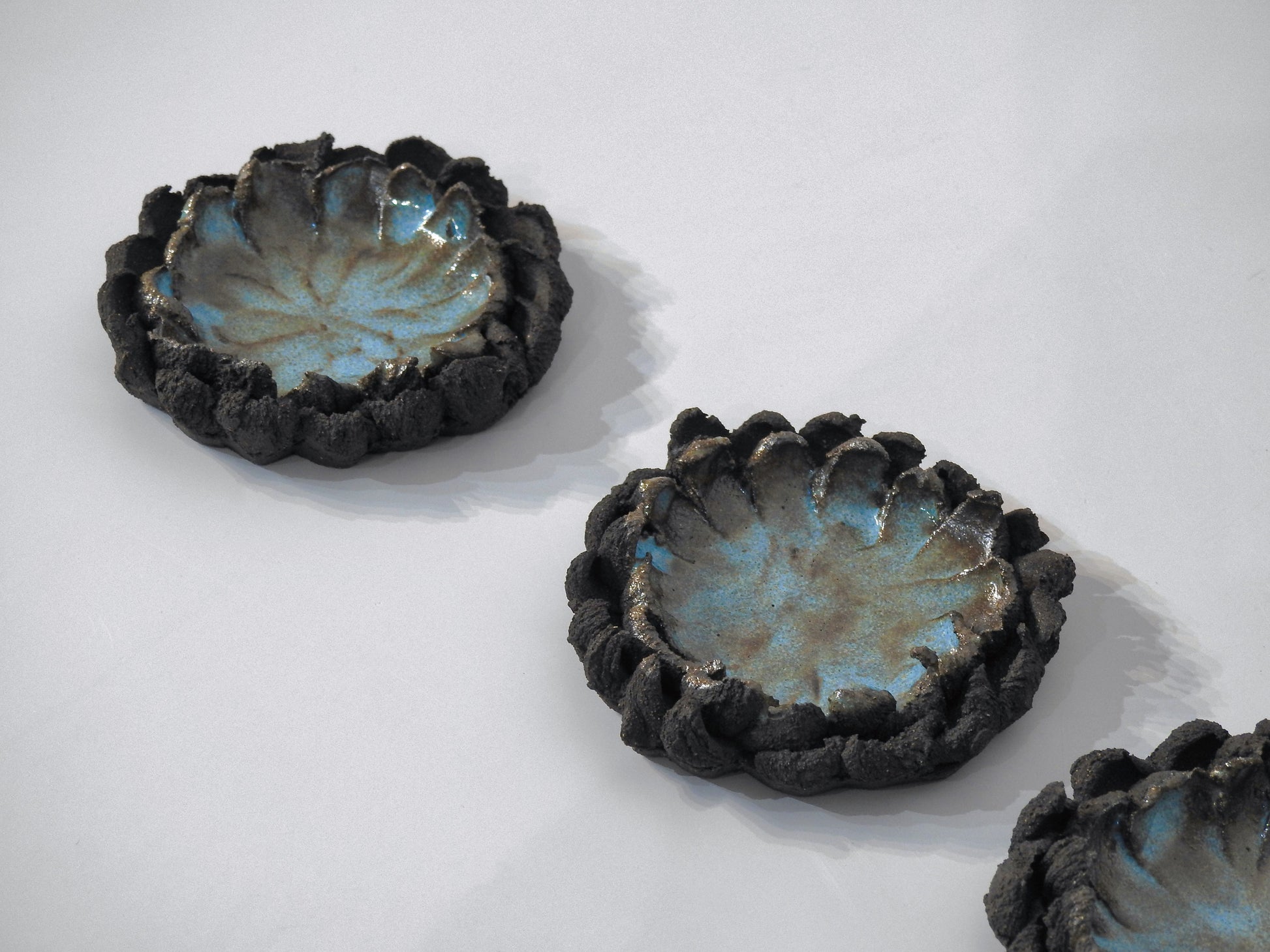 ashtray ceramic bowls with textured black exteriors and blue interior glaze on a cigarette holder