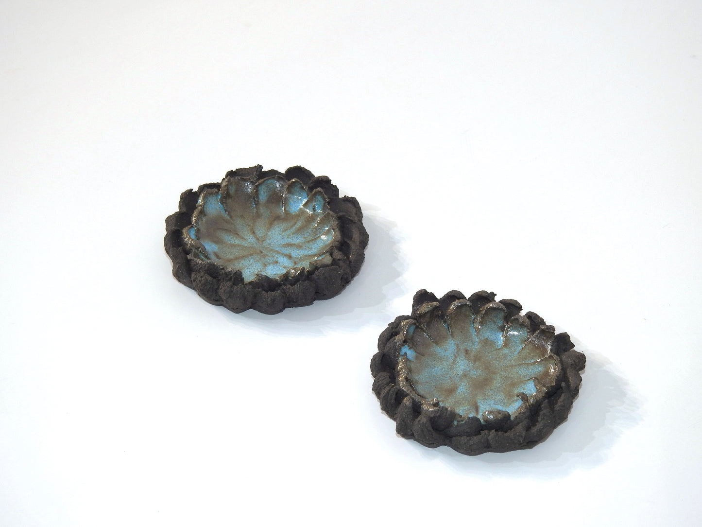  ceramic ashtray coasters with a textured surface and blue interior on a white background