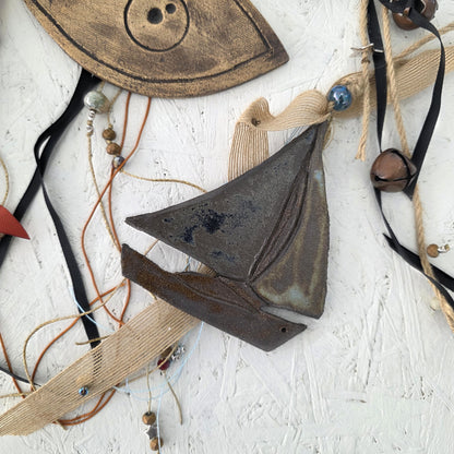 Decorative ceramic pieces on a textured white surface boat greek handmade art