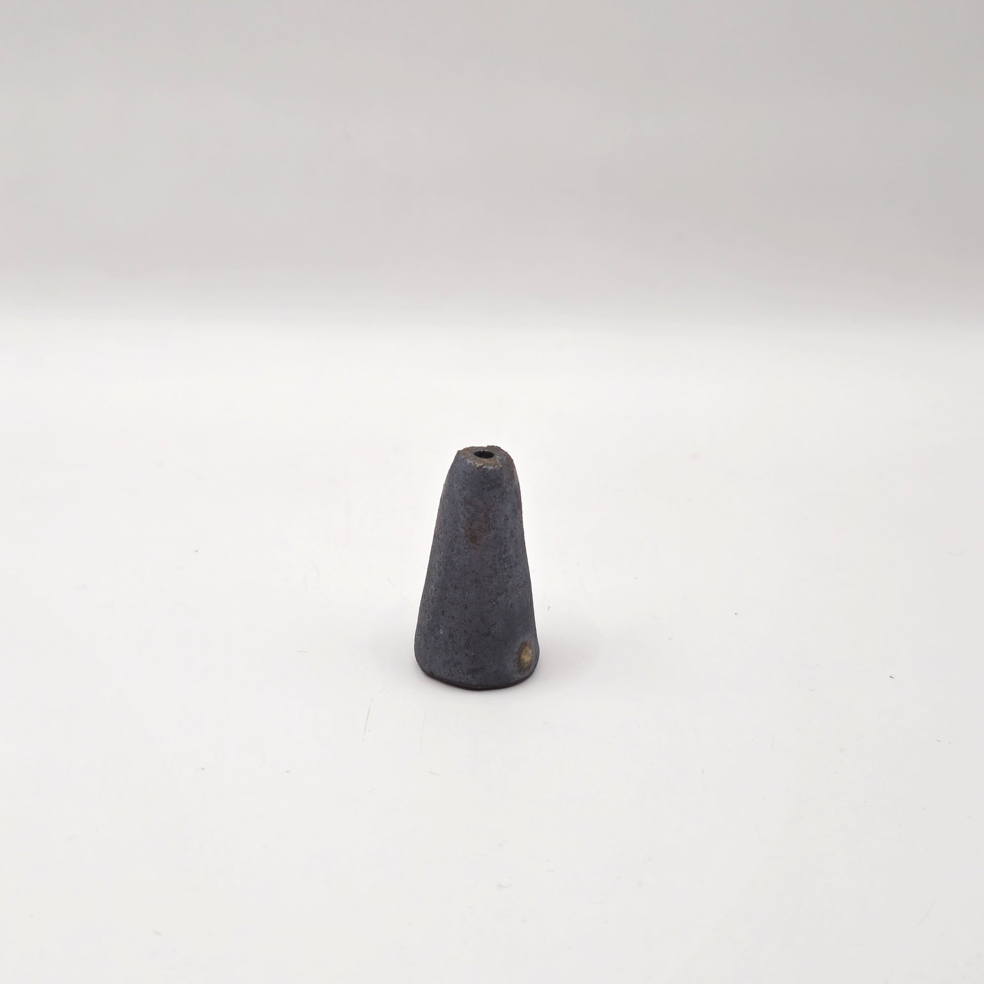 The SOIL INCENSE HOLDER Set features a small, gray, cone-shaped incense holder standing upright on a plain white background, highlighting elegant handmade stoneware and refined Greek craftsmanship.